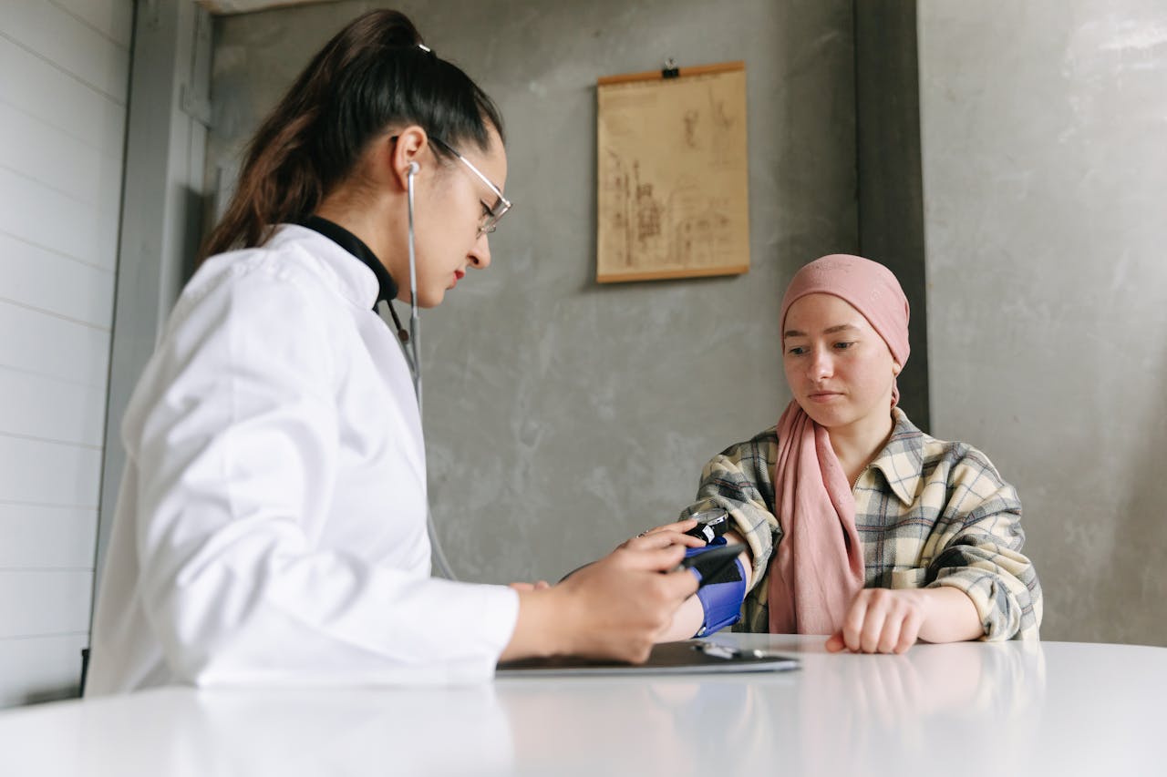 Home A medical professional checks a patient's blood pressure, depicting a caring healthcare environment.